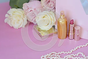 Perfume, gift, pearls, gentle roses on a pink background.