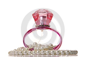 Perfume in a glass bottle and pearl beeds