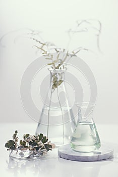 Perfume oils concept. Laboratory glassware with infused floral water on table