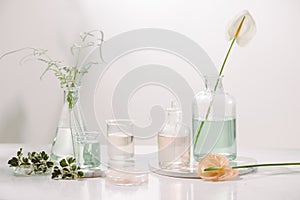 Perfume oils concept. Laboratory glassware with infused floral water on table