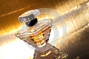 Perfume with reflection on gold background