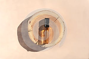 Perfume tester with brown liquid on a wooden tray. Top view