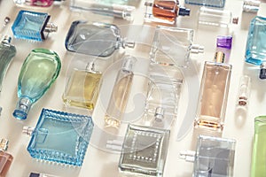 Perfumery, cosmetics and beauty industry background. A lot of transparent bottles of perfume and cologne and toilet