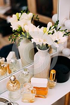 Perfumery and cosmetics on a dressing table with a mirror