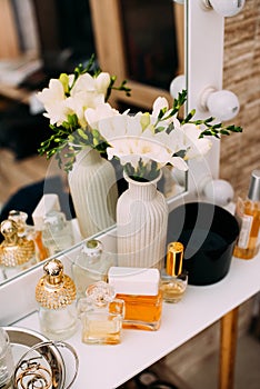 Perfumery and cosmetics on a dressing table with a mirror