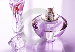 Purple perfume bottle on glossy background, sweet floral scent, glamour fragrance and eau de parfum as holiday gift and luxury