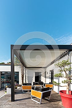 Pergola structure, awning and patio roof, garden lounge, chairs, metal grill surrounded by landscaping