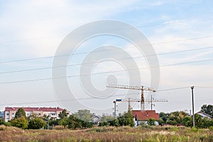 Peri urban scenery of the suburb of Belgrade, with cranes on a construction site in the middle of fields