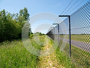Perimeter fence around Manchester International Airport sunny summers day with a blue cloudless sky