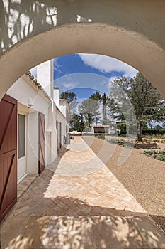 Perimeter hallway with terracotta floors in an Andalusian-style country house with white walls, gravel paths and quite a variety