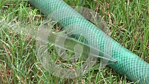 Perished hose pipe with water spurting from a hole.