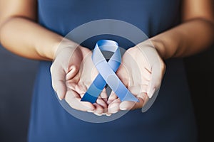 Periwinkle blue ribbon awareness with color bow on woman& x27;s hand for stomach and small intestine cancer, esophageal