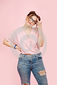 Perky emotional girl in loose pink top and jeans looks up photo