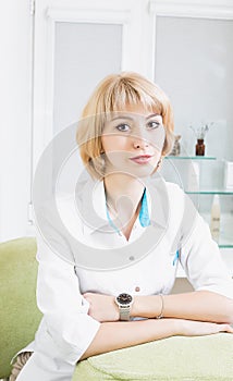 permanent beautician beautiful girl sits in a white coat in kabinete.Doktor photo
