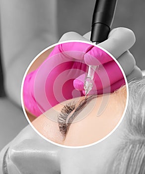 Permanent make-up for eyebrows of beautiful blonde woman in beauty salon. Closeup beautician doing eyebrows tattooing