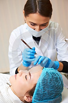 Permanent make-up wizard makes eyebrow correction procedure.