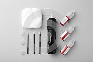 Permanent makeup equipment kit on light grey background, flat lay