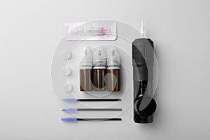 Permanent makeup equipment kit on light grey background, flat lay