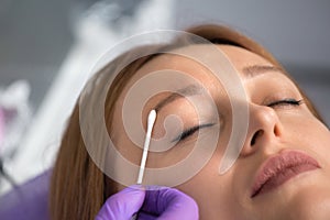 Permanent makeup, eyebrow microblading. Beauty master applies anesthesia to eyebrows