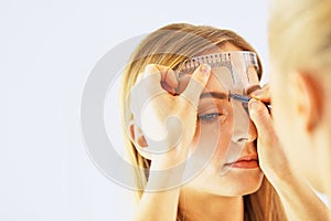 Permanent Makeup For Eyebrows. Beautiful Woman With Thick Brows In Beauty Salon. Beautician Doing Eyebrow Tattooing For