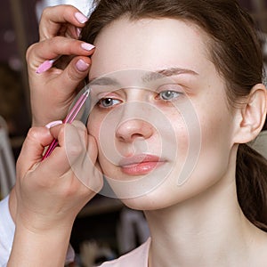 Permanent microblasting tattooing freckles to a woman in a beauty salon photo