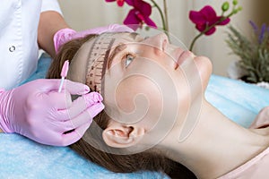 Permanent microblasting tattooing freckles to a woman in a beauty salon