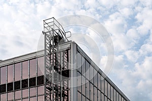 Permanently installed metal ladder at glass facade