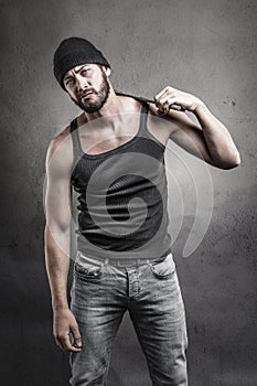 Perplexed man standing holding a wrench