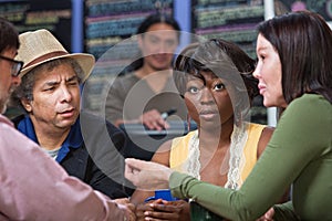 Perplexed Woman with Group in Cafe