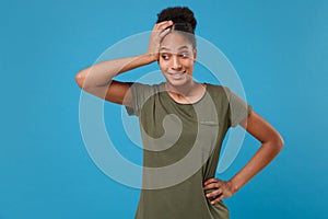 Perplexed young african american woman girl in casual t-shirt posing isolated on bright blue wall background in studio