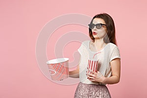 Perplexed young woman in 3d imax glasses posing isolated on pastel pink background. People sincere emotions in cinema photo