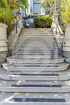 Perron staircase with anti-slip strips on each steps and metal fence and handrails