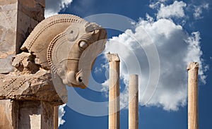 Persian Column with Bull Capital Against Blue Sky with White Fluffy Clouds from Persepolis of Shiraz in Iran