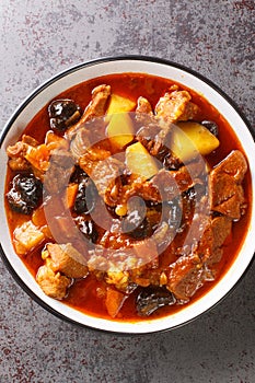 Persian Plum Stew Khoresht Aloo with lamb closeup in the bowl. Vertical top view