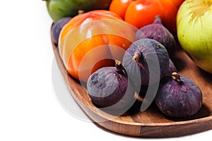 Persimmon and figs on a wooden tray on white