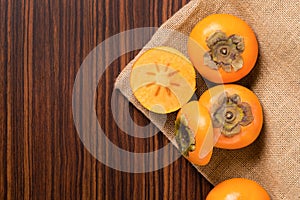 Persimmon fruit on rustic sack and wooden table