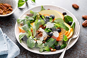 Persimmon fruit salad with blueberry, pecan nuts and ricotta chesse. Healthy food