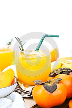 Persimmon juice in a glass And there are orange slices. Isolated white background, healthy drink concept