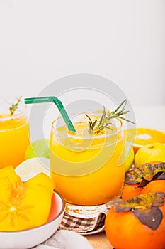 Persimmon juice in a glass And there are orange slices. Isolated white background, healthy drink concept