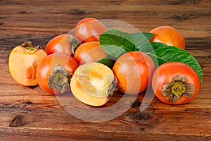 Persimmon. Kaki fruits on old wooden background photo