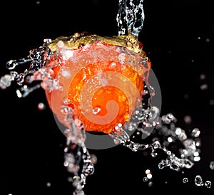 Persimmon in water on a black background