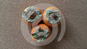 Persimmons on a Cork background