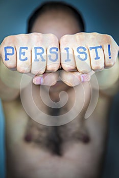 PERSIST! written on the fists of a man