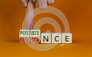 Persistence or resistance symbol. Businessman turns cubes, changes the word `resistance` to `persistence`. Beautiful orange