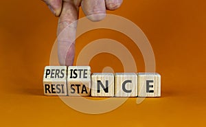 Persistence or resistance symbol. Businessman turns cubes, changes the word `resistance` to `persistence`. Beautiful orange