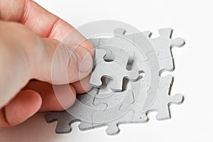 Person adding last piece of jigsaw puzzle