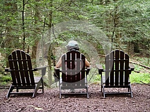 Person in Adirondack Chair Contemplating Forest