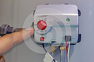 A person adjusting a gas control valve, residential gas water heater. Boiler Heating system