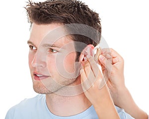 Person adjusting hearing aid