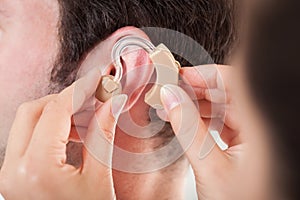 Person Adjusting Hearing Aid photo